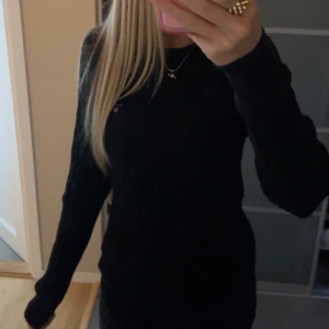 Svart kabelstickad tröja från Gant - Svart kabelstickad tröja från Gant i stretchig bomull. Klassisk modell med rund halsringning, diskret Gant-logo broderad på bröstet och långa ärmar. Perfekt för dig som gillar stilrena och tidlösa plagg. Använd ett fåtal gånger. Original pris 1600.