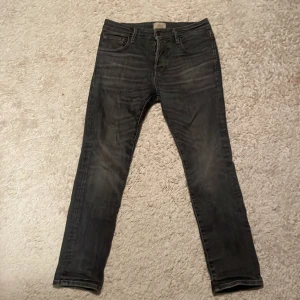 Jack & Jones svarta slim straight jeans - Svarta jeans från Jack & Jones i modellen Slim Straight. Snygg tvätt med diskreta slitningar och klassisk femficksdesign. Jeansen har normal passform och raka ben, perfekta för en chill och stilren look. Materialet är jeans med en mjuk känsla. Ny pris 1200kr