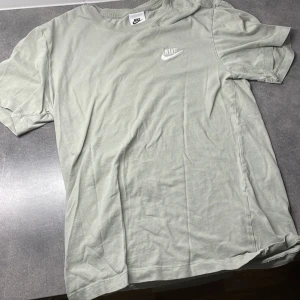 Ljusgrön Nike t-shirt i bomull - Snygg ljusgrön t-shirt från Nike med broderad vit logga på bröstet. Klassisk passform och rund halsringning. Tillverkad i mjuk bomull som är skön att ha på sig hela dagen.