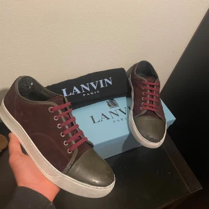 Vinröda/olivgröna skor från Lanvin - Vinröda/Olivgröna skor / märke: Lanvin / skick 7,5/10 Defekter syns på bild 1,2,3 / storlek 42 / Box och dustbag medföljer / kontakta via intresse eller annat och pris kan diskuteras ned nån 100 lapp eller två såklart!🙏