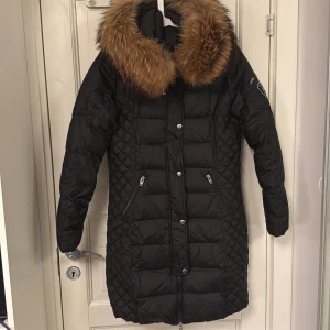 Rockandblue dunjacka - Rockandblue Vinterjacka med avtagbar päls. - Fodrade fickor med dragkedja. - Två innerfickor med dragkedja. - Tvåvägsdragkedja framtill med tryckknappar.  Använd men fint skick! Bara lilla bandet för att hänga upp jackan på krok som lossnat. (Se bild)   Står storlek 40 men liten i storleken. Skulle säga att den passar vanligtvis 36/38  