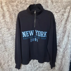 Svart half zip sweatshirt  - Svart sweatshirt med half zip och hög krage. E:t i texten är lagat.