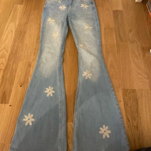 Blåa bootcut jeans från hollister w24 L32 - Super fina jeans till salu med blommor på. 