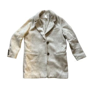 Beige kappa - HM - Beige kappa från HM. En äldre version men knappt använd! 