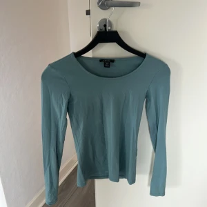 Blå långärmad tröja från Amisu - En stilren blå långärmad tröja från Amisu med rund halsringning. Tröjan är i mjuk bomull och har en enkel, klassisk passform som funkar till många olika outfits. Perfekt för dig som gillar basic men snygg stil.