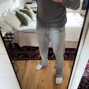 Ljusgrå Jack & Jones vintage jeans - Säljer ett par klassiska ljusgrå Jack & Jones jeans med rak passform. Normal midja och är tillverkade i slitstarkt denim. Perfekta för dig som gillar Archive stil  och avslappnad look. 