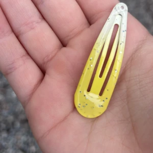 Gul glittrig hårklämma - Snygg hårklämma i gul färg med glittriga detaljer. Klämman har en droppformad design och är perfekt för att ge din frisyr lite extra bling. Passar dig som gillar färgglada accessoarer och vill sticka ut.