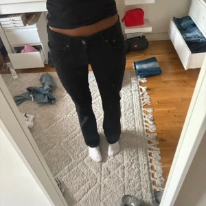 Svarta bootcut jeans från Zara - Svarta jeans från Zara med bootcut-modell och low waist. Byxorna har normal passform och är tillverkade i ett stretchigt bomullsmaterial som sitter snyggt över höfterna och släpper ut vid bensluten. Perfekta för en clean och stilren look. Dom är använda få gånger och i ny skick 
