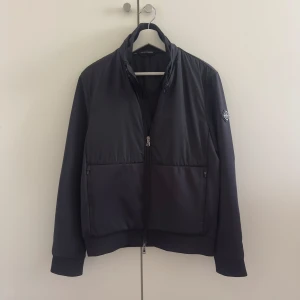 J.Lindeberg Cardigan  - Säljer nu denna riktigt snygga cardigan/hybrid-jackan från J.lindeberg. Knappt använd och i mycket gott skick, nypris ligger på 3000kr, mitt pris är 500. Perfekt nu till hösten. //MVH