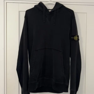 Svart hoodie från Stone Island - Svart Stone island hoddie. Den har blivit lite sliten på ena armbågen som du kan se på ena bilden men den har tagits väl hand om. Märket har alltid tagits av innan tvätt. Nypris (3800kr). Mitt pris 400 kr. Storlek L