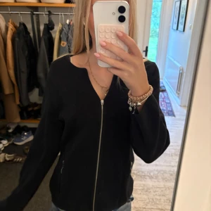 Svart stickad cardigan jacka med dragkedja - Säljer en svart stickad cardigan jacka med hel dragkedja framtill och två fickor med dragkedja. Jackan har en enkel och clean look med långärmade ärmar och rundad axlar, perfekt för en stilren look!💞
