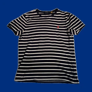T-shirt Polo Ralph Lauren - Stilren marinblå t-shirt från Polo Ralph Lauren i ett randigt mönster | Storlek M | Utmärkt skick, knappt använd | Hör av dig vid frågor