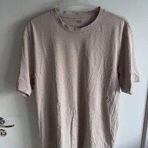Beige t-shirt från lager 157 - Strl L - Enkel och stilren beige t-shirt från 157. med rund halsringning och normal passform. Tillverkad i mjuk bomull och är i ett mycket bra skick.