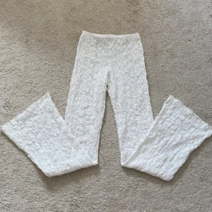 Vita spetsbyxor - Superfina vita byxor från Gina Tricot i spets med blommigt mönster. De är bootcut och elastisk midja för extra komfort. Passar alla från 168 cm långa och neråt. Perfekta för dig som vill sticka ut med en unik och fräsch look.