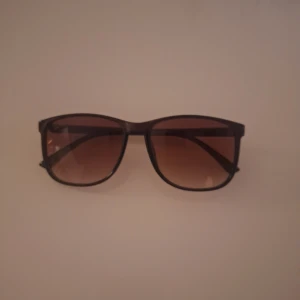 Ray-Ban Boyfriend solglasögon - Snygga solglasögon från Ray-Ban med bruna bågar och tonade bruna glas. Klassisk fyrkantig form och diskret logga på skalmarna. Perfekta för soliga dagar och ger en cool vibe till din stil. Pris ej hugget I sten 