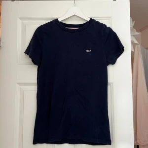 Mörkblå t-shirt Tommy Hilfiger - Mörkblå t-shirt från Tommy Jeans med klassisk passform och liten logga på bröstet. Sparsamt använd 