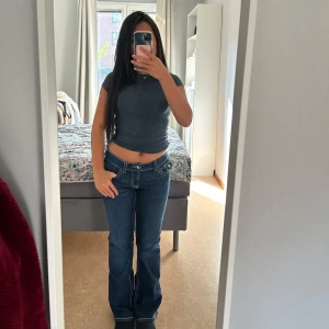 Mörkblå bootcut jeans - Säljer ett par få använd mörkblå bootcut jeans med bootcut-modell. Har den i storlek 158. Byxorna har låg midja och klassiska fickor både fram och bak, med en liten knappdetalj på bakfickan. 