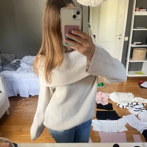 Beige offshoulder stickad tröja H&M - Supermysig beige stickad tröja från H&M med bred offshoulder-krage och långa ärmar. Ribbad struktur och loose passform som ger en chill vibe. Perfekt att styla med jeans eller kjol för en enkel men snygg look. Tröjan är i S och jag använder oftast XS men jag ville ha den oversized som den är för mig i strl S.