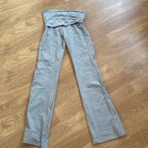 Grå bootcut byxor i polyester XS/ yogapants / rozkloszowane rajstopy - Snygga grå bootcut byxor i mjukt stretchigt material med bred linning. Byxorna är tillverkade i 95% polyester och 5% elastan, vilket gör dem riktigt bekväma och följsamma. Perfekta för en chill och trendig look.