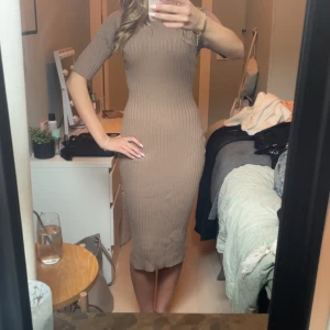 Beige ribbad midiklänning - Säljer en beige ribbad klänning med tight passform och midilängd