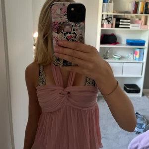 Rosa halterneck topp från Zara - Supersöt eftertraktad ljusrosa halterneck topp från Zara. Toppen har en knutdetalj framtill och är tillverkad i ett lätt, flowy material som ger en luftig känsla. Perfekt för sommardagar och när du vill känna dig extra fin. Använd endast 1 gång💓