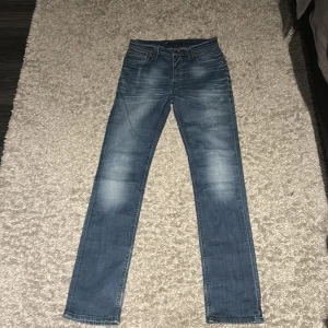 Blå Nudie Jeans straight  - Säljer ett par klassiska blå jeans från Nudie Jeans i rak modell. Storlek 29,34.