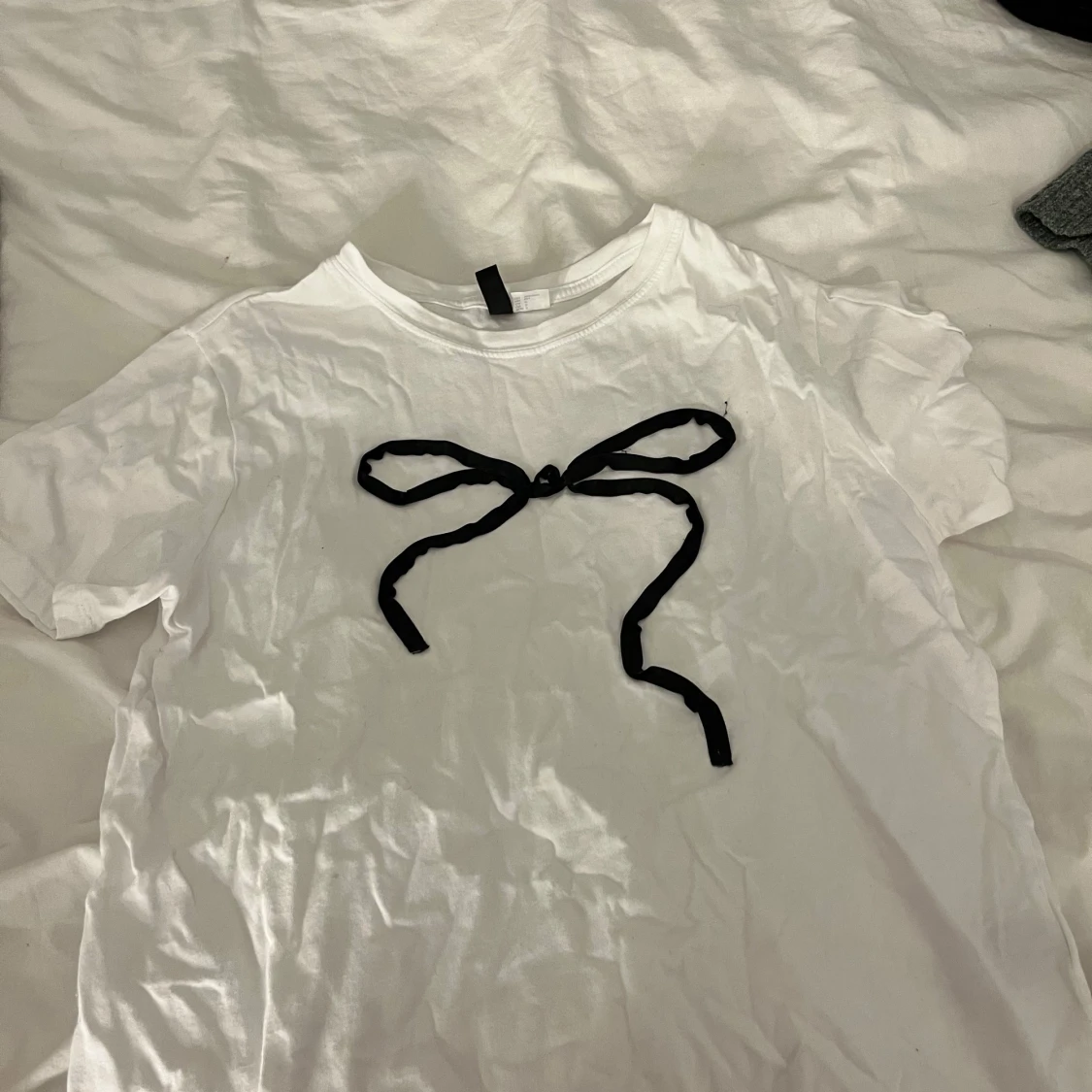 Vit t-shirt med svart rosett från Divided