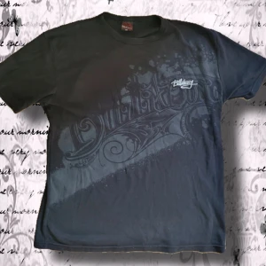  Billabong t-shirt - Cool svart t-shirt från Billabong i storlek XXL med snyggt tryck framtill i grå toner och grafisk design. Klassisk passform med rund hals och korta ärmar. Perfekt för dig som gillar streetwear och vill ha en avslappnad stil.
