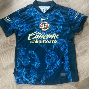 Blå Club América matchtröja 2024/25 - Säljer en fotbollströja från Club America, det är bortatröjan från 24/25. Sjukt snygg design med mycket detaljer. Otroligt bra skick använd kanske 2-3 gånger