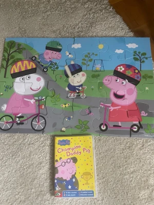 Greta gris stor pussel +DVD Greta Gris  - Bilden visar ett Peppa Pig-pussel och en DVD allt i nyskick 