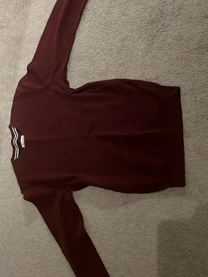 Vinröd långärmad tröja från pier one - Snygg vinröd långärmad tröja från pier One med rund hals. Tröjan är gjord i 100% bomull. Storlek M