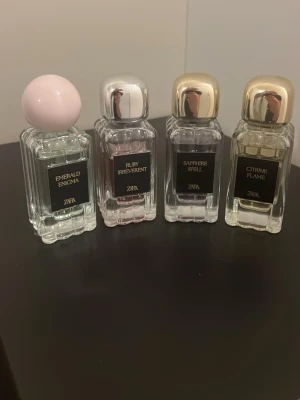 Fyra Zara parfymer, samling - Samling med fyra Zara parfymer: Emerald Enigma, Ruby Irreverent, Sapphire Spell och Citrine Flame. Snygga flaskor med olika färg på korken. Perfekt för dig som vill testa flera dofter från Zara och hitta din favorit.