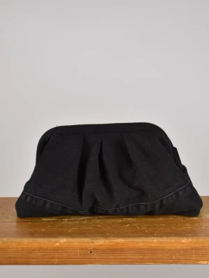 Clutchväska  - Clutchväska, perfekt till fest och vardag.  Denna väskan är gjord av svart jeans på utsidan och blått möbeltyg på insidan.  Innuti finns en ficka där du kan lägga småsaker och du stänger enkelt med clutch ramen.  Clutchram ca 18cm bredd, bredd nertill ca 25cm, höjd ca 15cm. 
