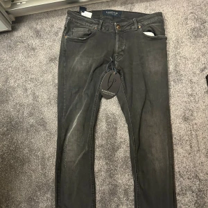 Handpicked svarta skinny jeans - Svarta jeans från Handpicked med skinny passform och klassisk femficksdesign. Jeansen har en snygg tvättad look, metallknapp med logga och läderpatch bak i midjan. Materialet är mjukt och stretchigt jeans, perfekt för en cool och modern stil.