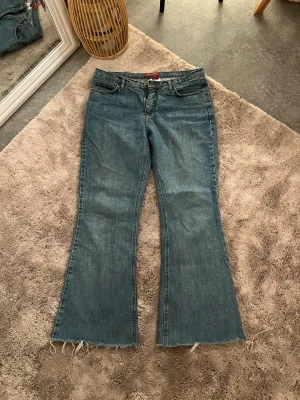 Levis bootcut jeans med rå kant - Snygga blå jeans med bootcut passform och rå, fransig kant . Jeansen är i denim och har en avslappnad vibe.