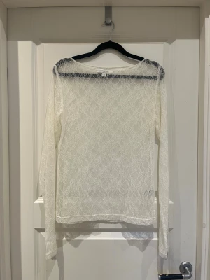 spets topp - säljer denna vita spets toppen man kan ha över ett linne eller en bandeu topp, jättefin till fest eller liknande! Aldrig använd. Storlek M men passar även S🤩
