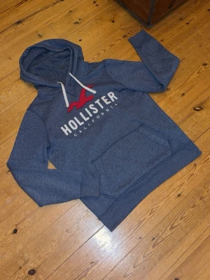 Mörkblå hollister hoodie! - Nu säljer jag min mörkblå aktiga hollsiter hoodie i storlek M. Hoodien har ett vitt broderat märke. Priset är inte hugget i sten😇 Tveka inte med att höra av dig för minsta lilla fundering🙏