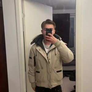 Beige Canada Goose bomberjacka - Säljer en beige bomberjacka från Canada Goose, riktigt bra skick och äkta såklart, pris är inte hugget i sten så kom med förslag.