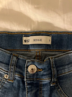 Blå skinny jeans från Gina Tricot,  Perfect Jeans - Säljer ett par klassiska blå skinny jeans från Perfect Jeans, modell BONNIE.  De är stretchiga och har normalhög midja för en bekväm passform. Tyget formar sig och sätter sig efter kropps former. 