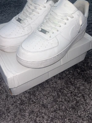 Nike Air Force 1 vita sneakers - Klassiska Nike Air Force 1 i färgen vit. Rätt så bra skick förutom sulan inuti som smutsat ner sig från ”hälskydd” jag tidigare använt.                                           Hör gärna av er vid ev frågor🫡🤩