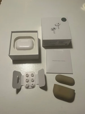 AirPods Pro 2a generationen  - Säljer ett par Apple AirPods Pro (2nd Generation).  Inkluderar extra öronproppar och kartong.   Otroligt ljud och brusreducering för musik eller poddar men mikrofonen vid samtal är sådär. Inget som dessa verkar vara anpassade för.   Garanti ska finns kvar enligt appen, se bild.  Skickar med ett beige fodral från ideal of Sweden.