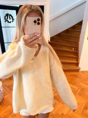 Beige  oversized stickad tröja - Supermjuk och fluffig ljusgul stickad tröja med v-ringning och oversized passform. Perfekt för lager på lager och ger en chill vibe till din outfit. Långa ärmar och enkel design som passar till allt. hm mohair!!
