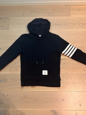 TIMS BLANC hoddie  - Mörkblå  hoodie i väldigt bra skick. Stilren design med vita ränder på ena armen som ger en clean och exklusiv look. Mjuk och bekväm, passar perfekt till vardags eller streetwear-outfits. Inga hål eller fläckar. Säljs eftersom den inte används längre.    Skickas snabbt 📦