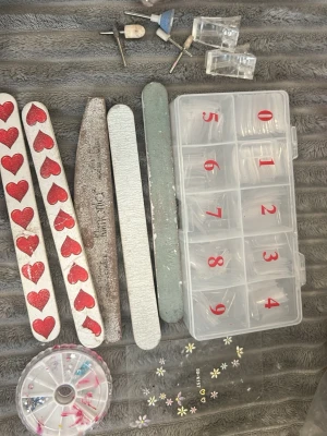 Nagelkit med filar och dekorationer - Nagelkit med flera nagelfilar, slipverktyg, plasttippar i olika storlekar i en organiseringslåda, hjul med nageldekorationer och små blommiga stickers. Perfekt för dig som gillar att fixa naglarna hemma.