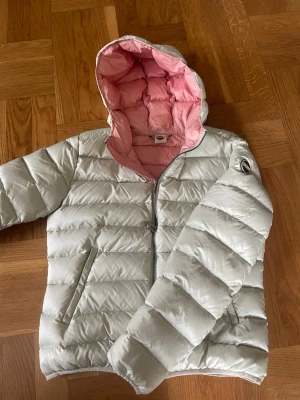 Ljus pufferjacka från Colmar, strl 46/sitter som S - Säljer en snygg ljus pufferjacka från Colmar med rosa insida. Jackan har dragkedja framtill, två fickor och quiltad design. Perfekt för kyliga dagar och riktigt skön att bära. Märke på ärmen och insidan i mjuk polyester.