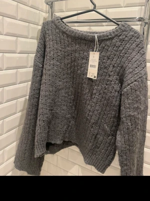 Stickad tröja NA-KD - Grå stickad tröja, helt oanvänd med prislapp kvar. Säljer för att jag råkade köpa fel storlek. Mjuk och snygg passform.