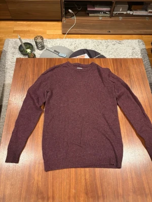 Vinröd stickad tröja med mockadetaljer från samsoe samsoe - Vinröd stickad tröja med rund hals och ribbade muddar. Tröjan har snygga bruna mockalappar på armbågarna som ger en klassisk touch. Perfekt för höst och vinter när du vill vara både varm och stilren. Men den har ett litet hål men som inte syns vid andväning och är lätt att sy igen. Därför sänker jag priset från 490 till 340