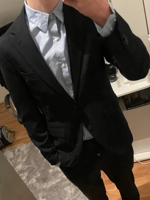 Ljusblå slim fit skjorta från H&M - Säljer en ljusblå skjorta från H&M i slim fit-modell. Skjortan har klassisk krage, knappar framtill och är tillverkad i bomull. Perfekt för dig som vill ha en clean och stilren look. Jag är 178 cm och väger 63 kg. Skriv för fler frågor 