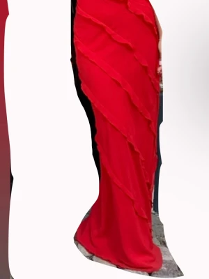 Röd långklänning med volanger från Mango - Säljer en röd långklänning från Mango med tunna axelband och snygga diagonala volangdetaljer längs hela klänningen. Klänningen har en figurnära passform och är tillverkad i ett lätt, flytande material som ger en elegant look.❤️