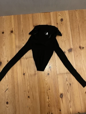 Svart ribbad polotopp från Divided - Svart långärmad polotopp från Divided i storlek XS. Toppen är ribbad och har en tight passform med hög krage. Perfekt att styla med jeans eller kjol för en snygg look.